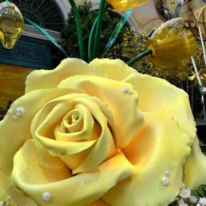 Rose jaune géante décorative au Bellagio Conservatory, avec perles et tulipes dorées en arrière-plan