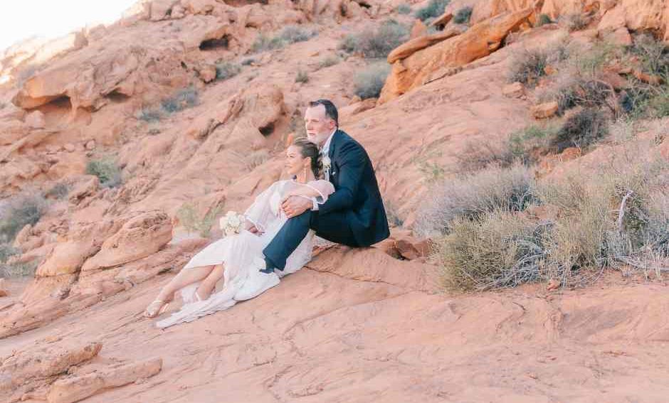Couple de mariés assis sur les roches rouges de Valley of Fire, moment intime au coucher du soleil – Crédit photo Pretty Day