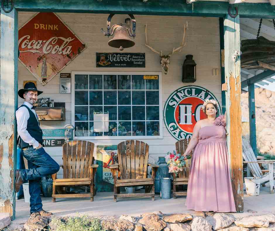Couple posant devant une façade vintage décorée d’enseignes rétro à Nelson’s Ghost Town – Crédit photo Pretty Day