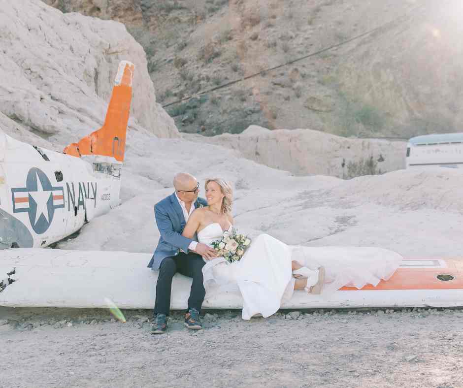 Couple marié assis sur une aile d’avion à Nelson Ghost Town près de Las Vegas, photo artistique par LesChroniquesDeVegas.