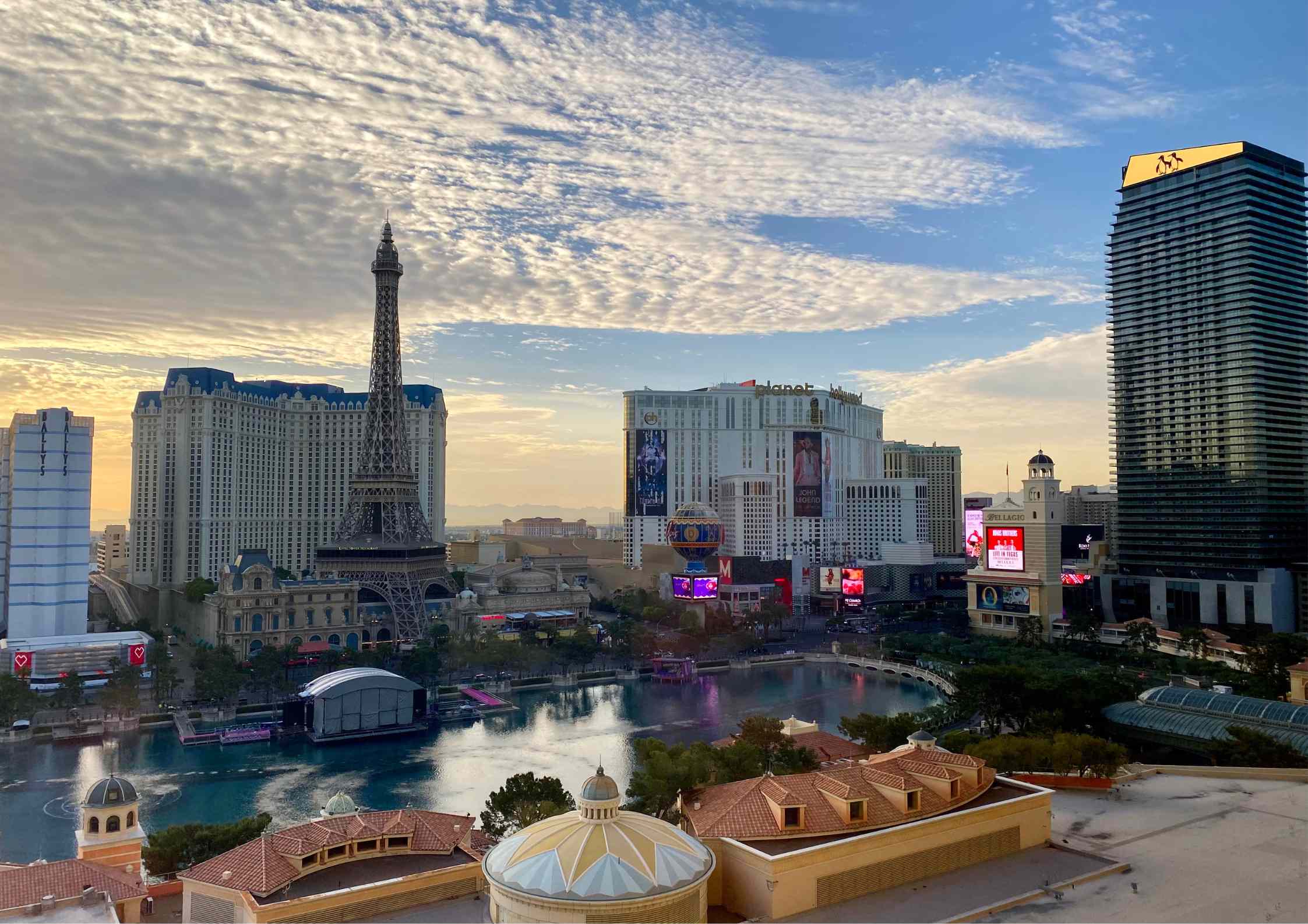 Vue panoramique du Strip de Las Vegas au lever du soleil, avec la Tour Eiffel du Paris Las Vegas et le lac du Bellagio.