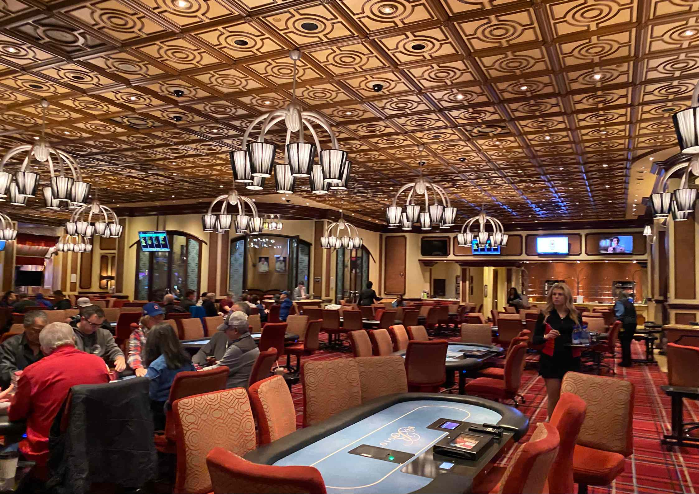 Salle de poker du Bellagio avec tables et décor élégant au plafond.