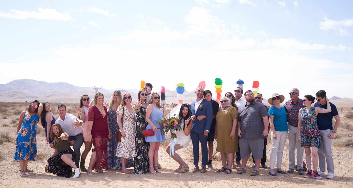 Mariés entourés de leurs invités devant les rochers colorés