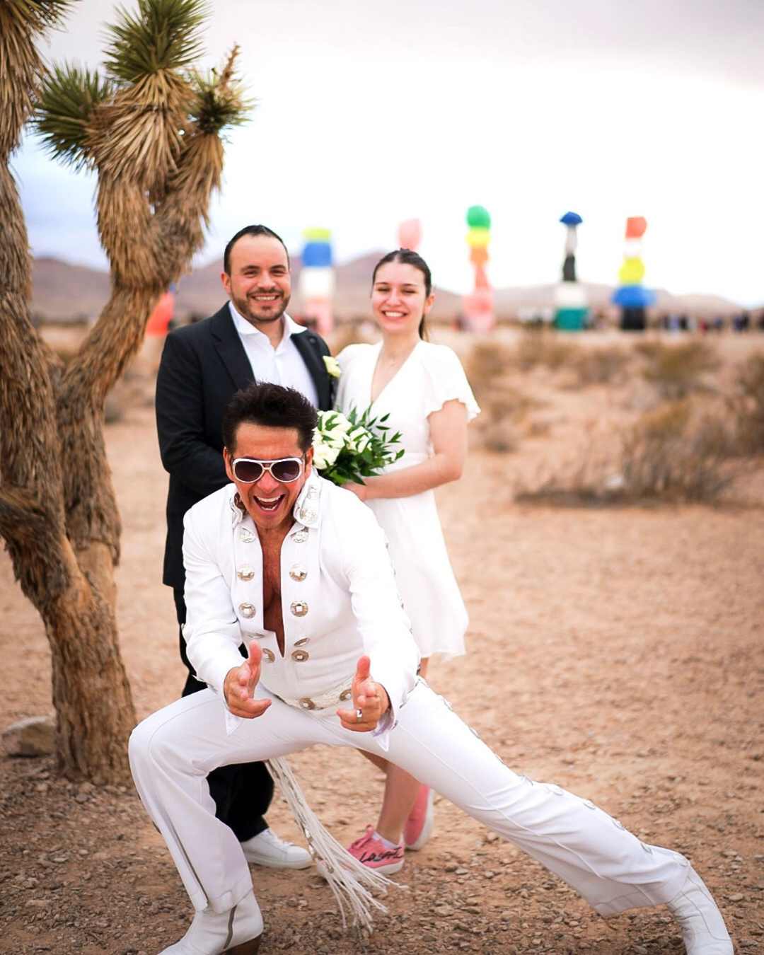 Officiant Elvis posant devant un couple dans le désert