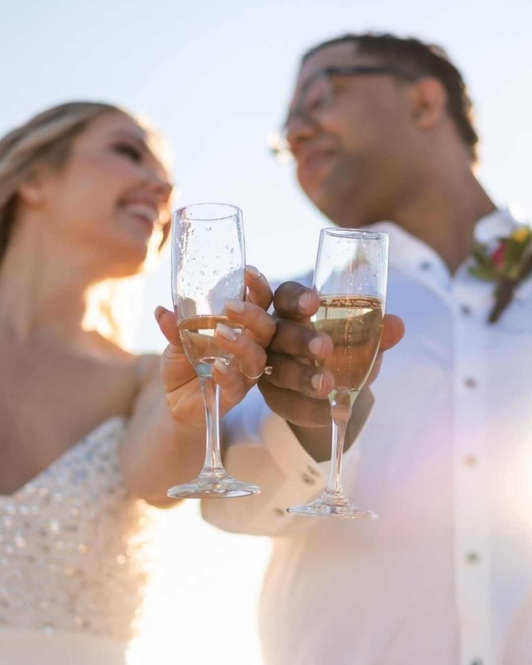 Mariés trinquant avec des flûtes de champagne