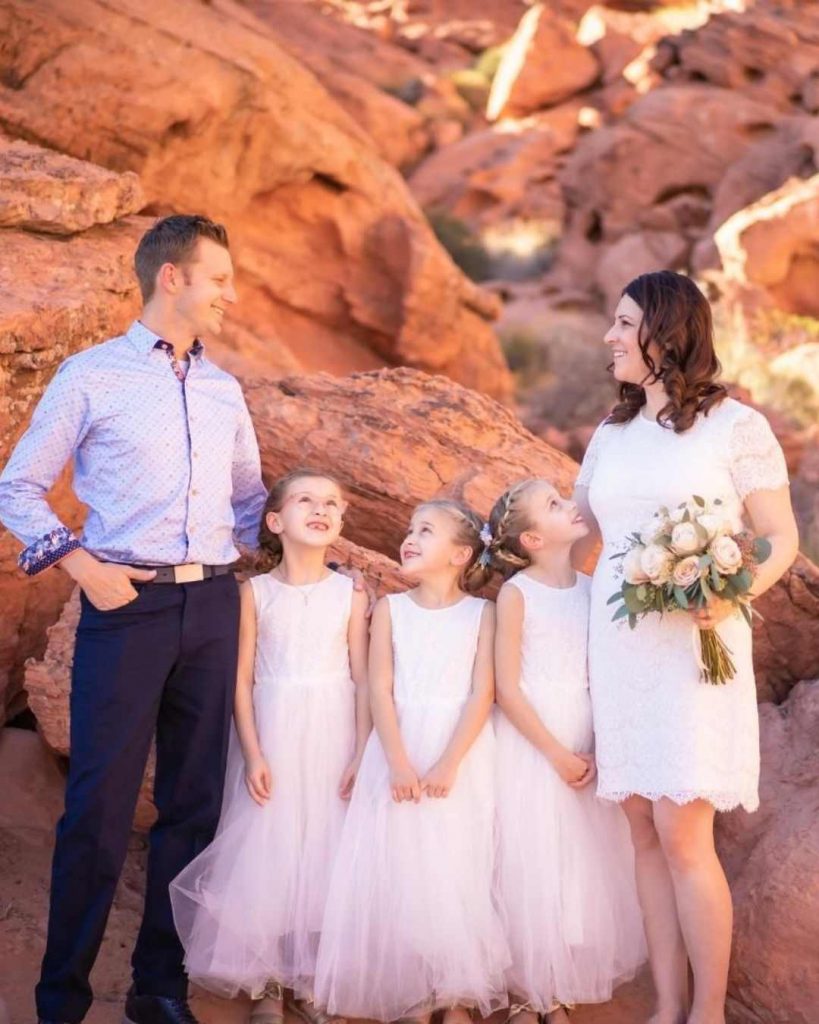 Couple et enfants souriants au pied de roches rouges