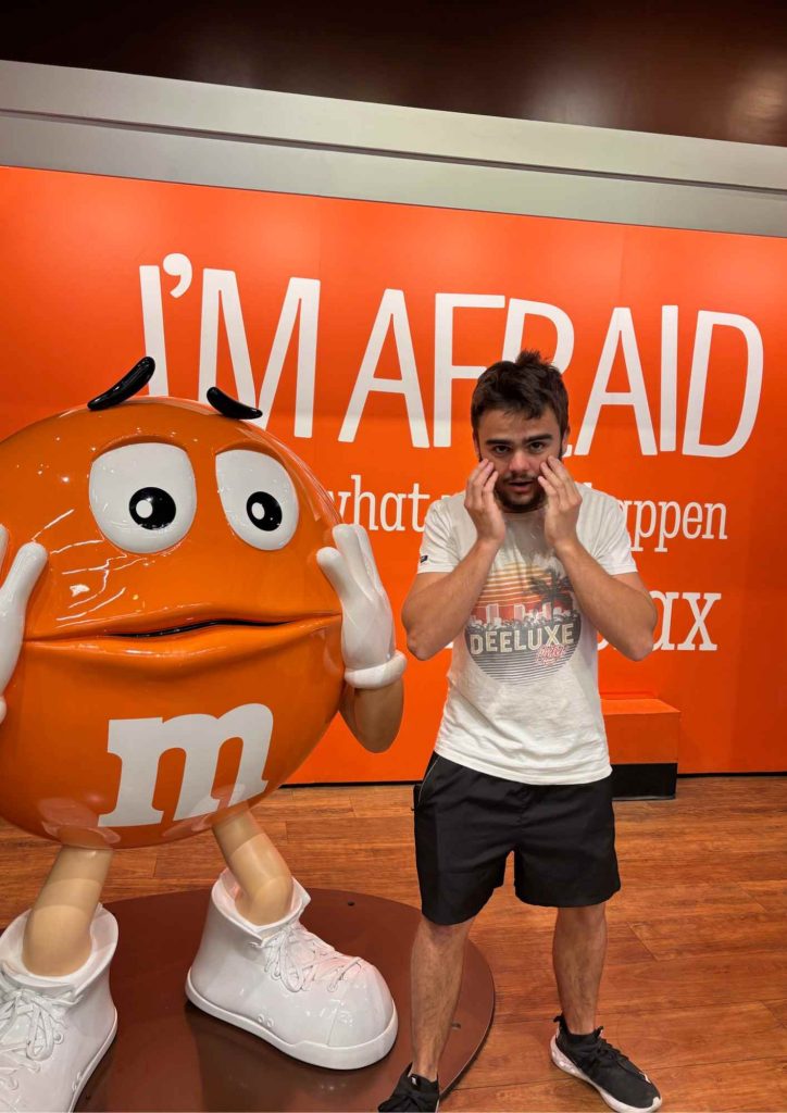 Statue Orange M&M’s à Las Vegas avec Kylian imitant la pose devant le mur “I’M AFRAID”.
