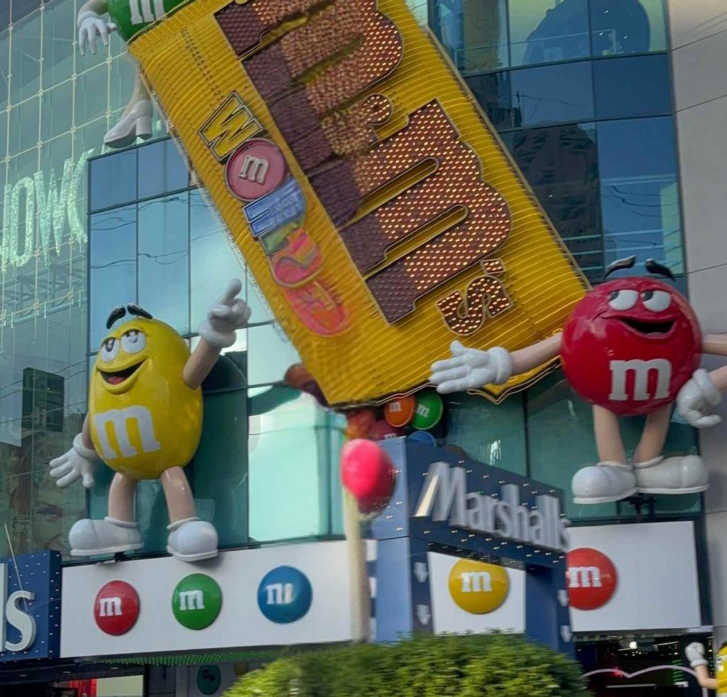 Gros plan sur le pack M&M’s géant et les statues Yellow et Red à l’entrée du magasin de Las Vegas.