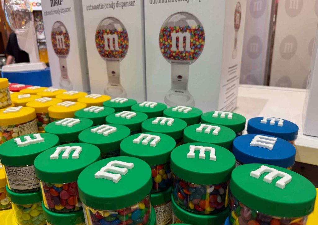 Gros plan sur pots M&M’s verts devant distributeur automatique