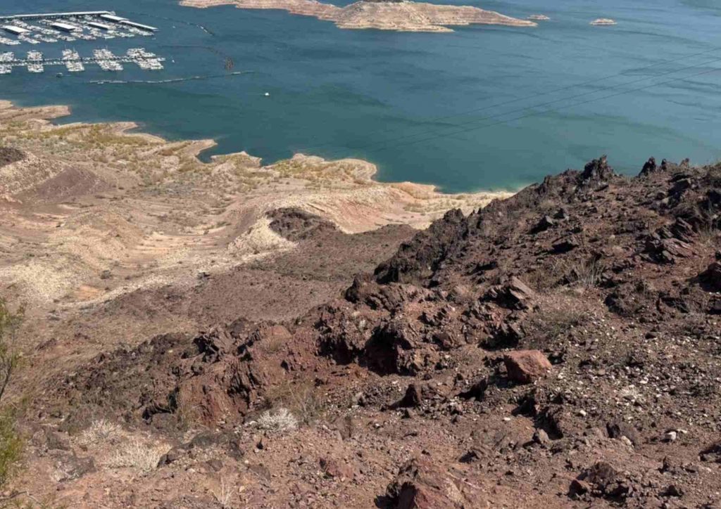Crête rocheuse dominant une étendue d’eau aux rives découpées.