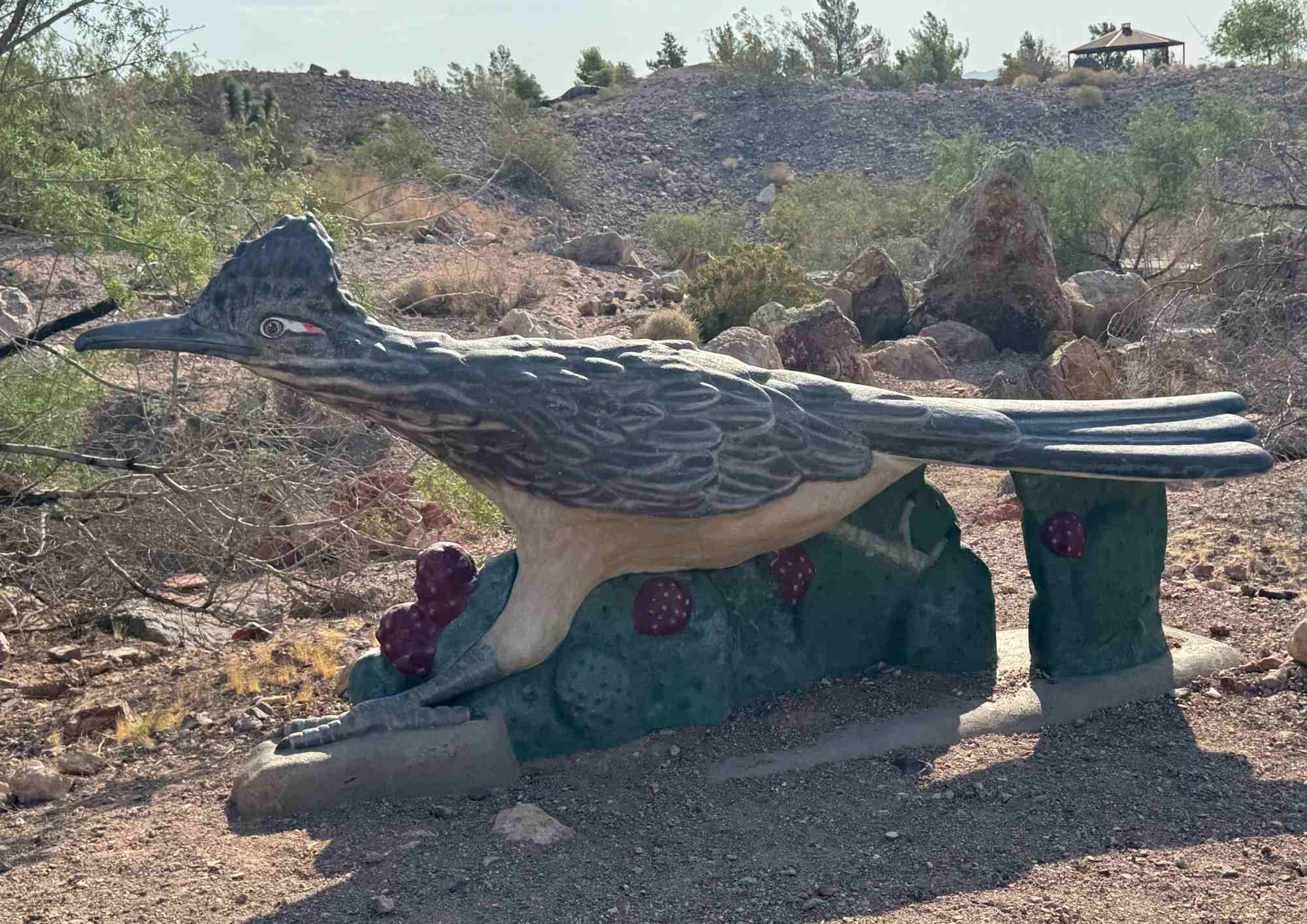 Sculture d'un Roadrunner installé sur un sol de gravier.