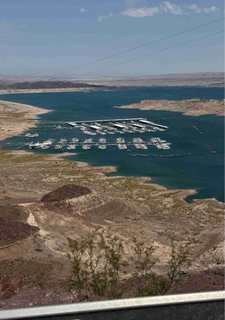 Vue en hauteur sur un plan d’eau et une marina avec des pontons et des bateaux.