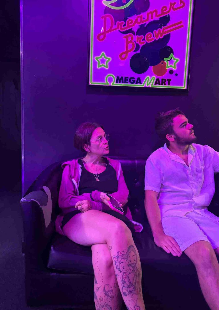 Visiteurs assis sous une enseigne Dreamer Brew à Omega Mart