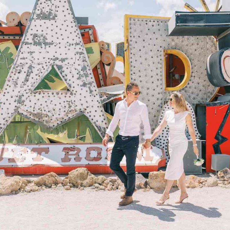 Couple marchant main dans la main au milieu des enseignes vintage du Neon Museum – Crédit photo Pretty Day