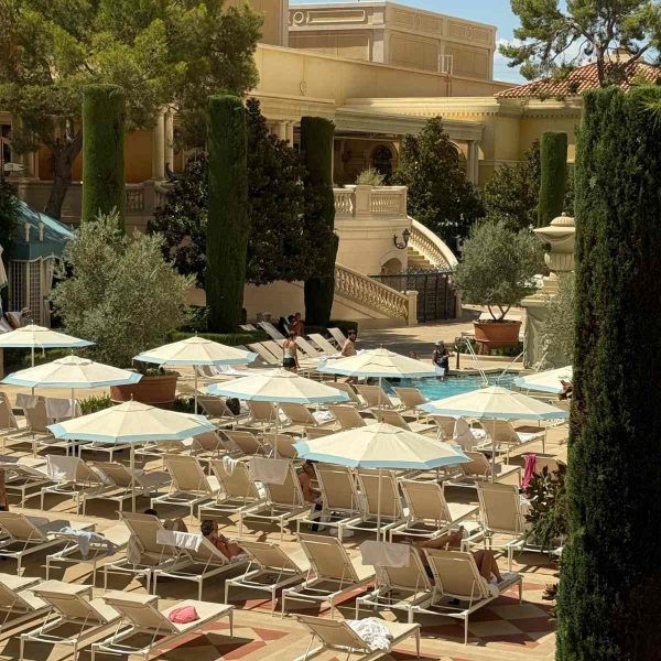 Espace détente piscine Bellagio Parasols blancs et transats au bord d’une piscine du Bellagio
